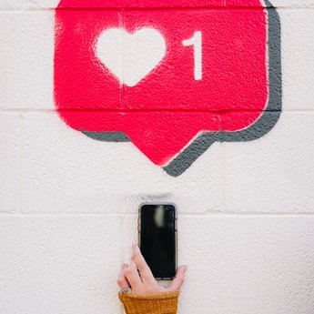 An instagram like icon spray-painted onto a brick wall