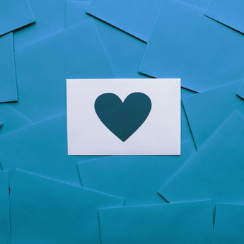 A white letter on a blue background with a blue heart