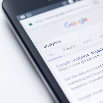 Mobile phone on Google with the search results for 'analytics'