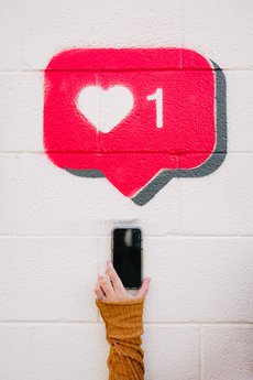 An instagram like icon spray-painted onto a brick wall