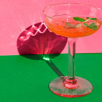 Cocktail glass on a pink and green backdrop